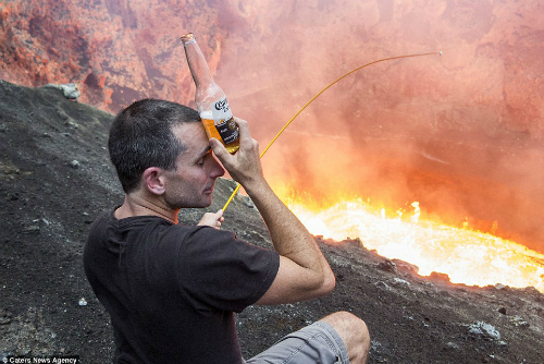 Vừa uống bia, Simon Turner người New Zealand lại vừa nướng kẹo dẻo trên miệng núi lửa dung nham đang sôi sục. Ảnh: Carters News Agency